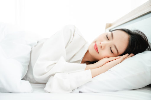 Young woman happy sleep on bed in morning time