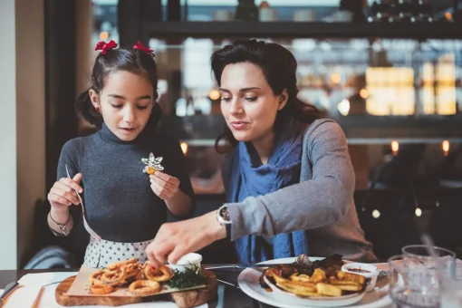 Mother and daughter enjoying lunch in restaurant
