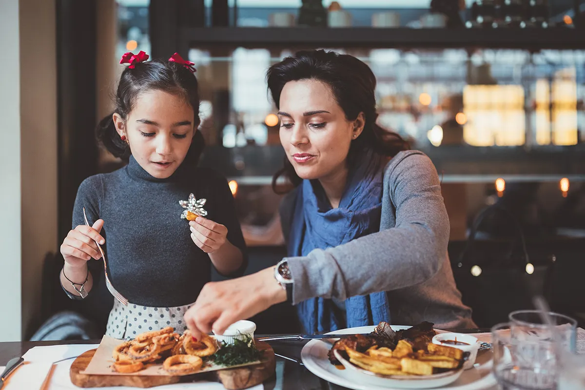 Mother and daughter enjoying lunch in restaurant