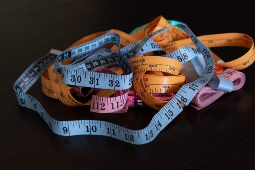 Photo of colorful measuring tapes tangled on a black background,