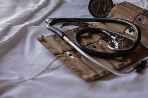 Photo of a blood pressure cuff and stethoscope laying on a bed