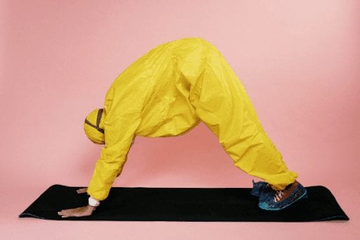 Person in hazmat suit doing yoga pose