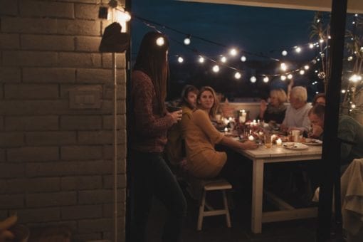 Family eating together outside in the evening for holiday gathering.